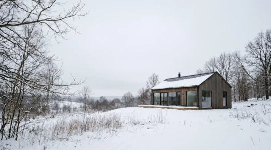 Vue architecturale d'une maison contemporaine à haute efficacité énergétique dans un paysage hivernal, démontrant le confort thermique passif